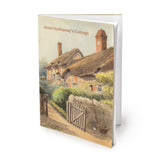 Souvenir notebook saying Anne Hathaway's Cottage. It features an atmospheric pastel watercolour painting of the cottage with the gate open and a basket and gardening tools positioned next to it. The notebook is slightly open, pages visible.