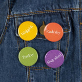 Four bright colourful (yellow, red,green and purple) button badges on a denim jacket.